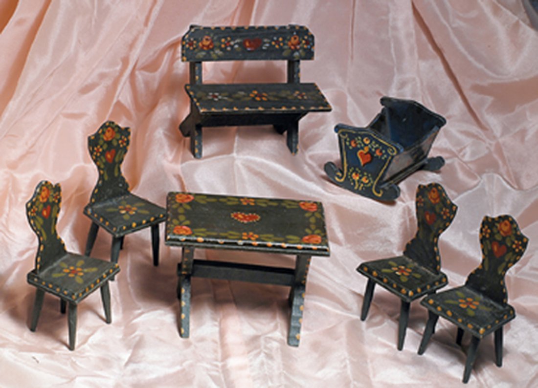 HANDPAINTED DOLL HOUSE FURNISHING GROUP. Includes:: HANDPAINTED DOLL HOUSE FURNISHING GROUP. Includes: Table, four chairs, bench and cradle. Table height 3 ¾”. All are finished in dark green enamel with extensive decorative painting. Commentary: Exc