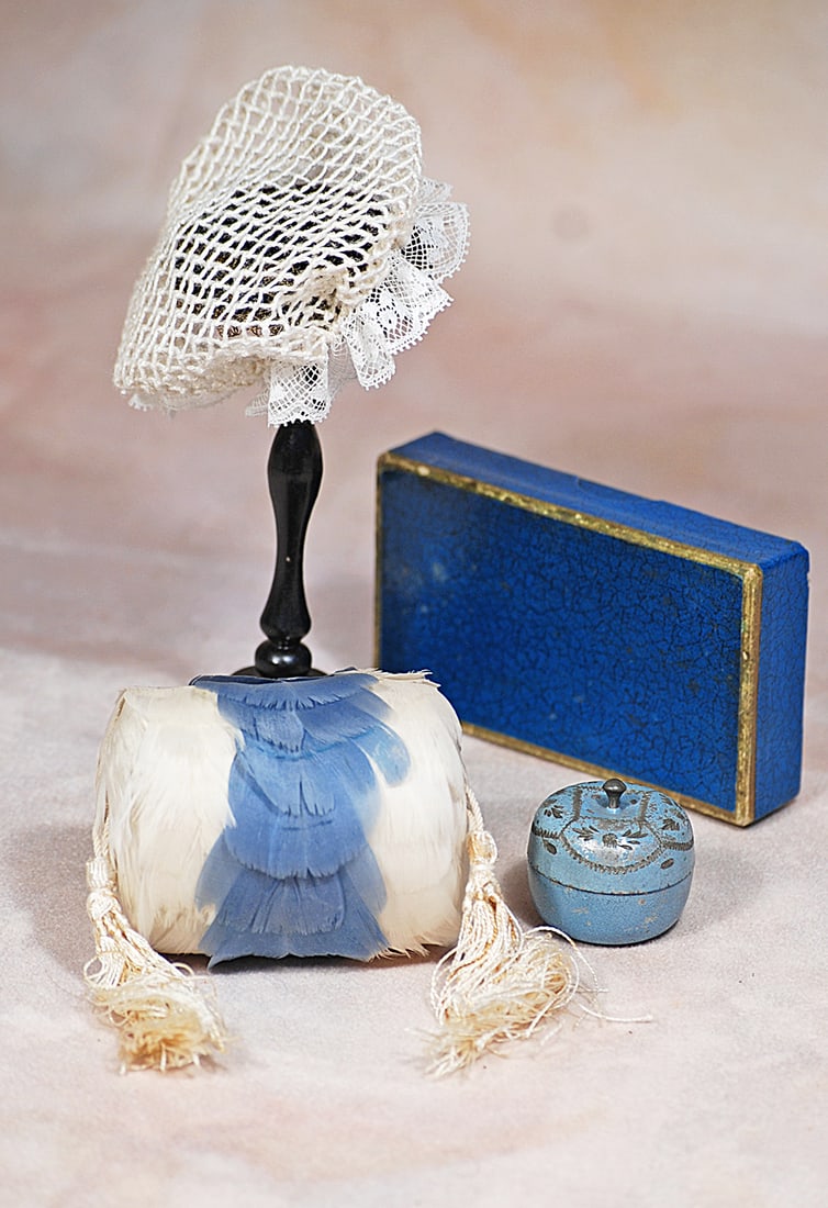 ACCESSORIES FOR POUPEE: Includes: 2 ½” white and soft blue feather muff with silk lining and white silk tassels; 1” French blue round-shaped metal trinket box with lid and impressed designs; 4” x 2 1/4