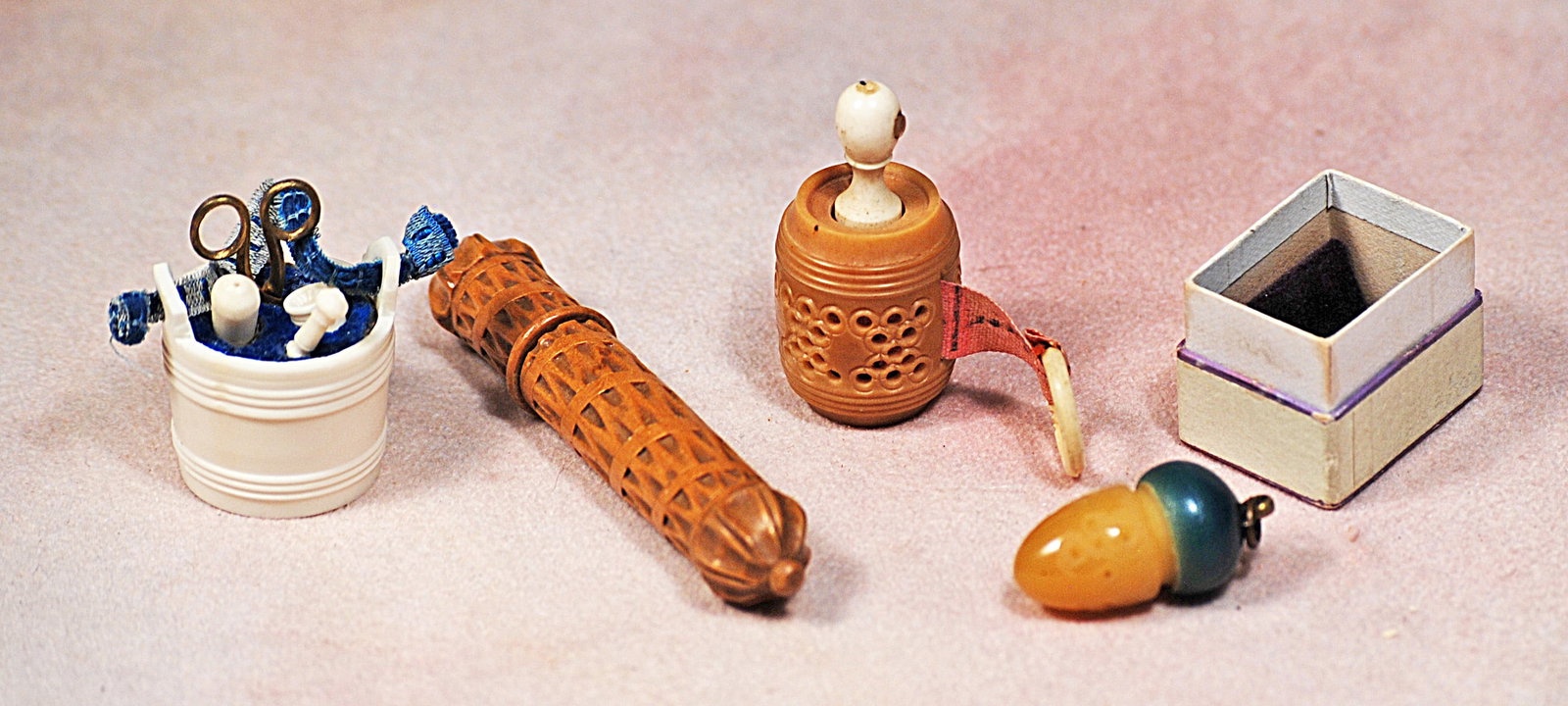 COLLECTION OF SEWING TOOLS.: 73. COLLECTION OF SEWING TOOLS. Includes: 3” carved wooden needle case with lattice design; 1 ½” carved wooden tape measure case with lattice work design and tape with bone loop