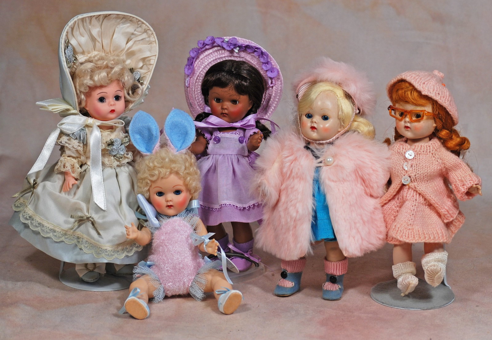FIVE VOGUE DOLLS: 82. FIVE VOGUE DOLLS. 8”. Vintage doll with painted lashes, straight legs, blonde hair, untagged Ginny cotton dress, pink fur coat and hat, blue leatherette shoes; vintage doll with walker body,