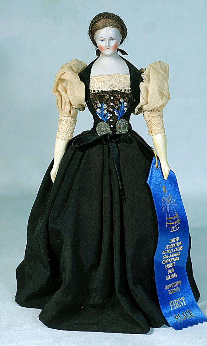 GERMAN PORCELAIN LADY KNOWN AS BIEDERMEIER: 13”. Porcelain shoulderhead, painted features, blue eyes, red and black eyeliner, tapered brows, closed mouth, original brown mohair wig, original cloth body with carved wooden lower limbs, pain