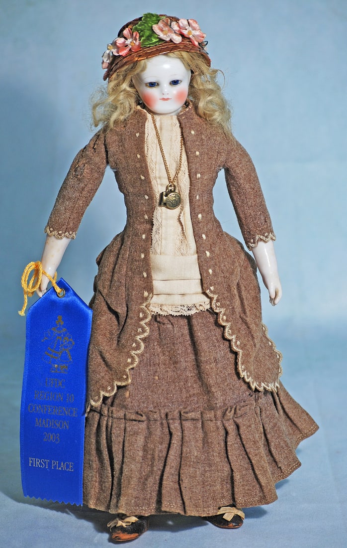 FRENCH PORCELAIN POUPEE BY ROHMER WITH ORIGINAL BODY STAMP: 13”. Porcelain shoulderhead, inset cobalt blue glass eyes, painted lashes, delicately feathered brows, closed mouth, rose-blushed cheeks, original blonde mohair wig over cork pate, kid leather p