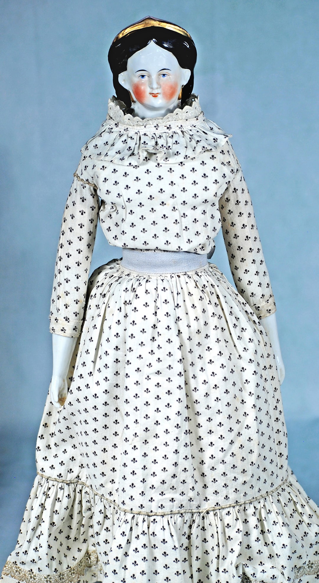 GERMAN PORCELAIN LADY WITH GOLD LUSTRE CORONET AND EARRINGS: 18 ½”. Porcelain shoulderhead, sculpted gold luster coronet with black hair waved behind the ears, arranged in three horizontal rolled curls, gold luster earrings, painted features, blue ey