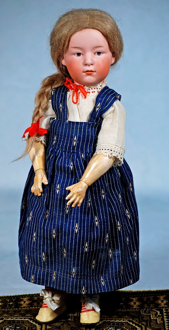 GERMAN BISQUE POUTY CHILD BY GEBRUDER HEUBACH: 13”. Marks: 8970 Germany 4. Bisque socket head, painted features, intaglio blue eyes, upper eyeliner, tapered brows, closed mouth, original light brown mohair wig, composition and wooden ball-jo