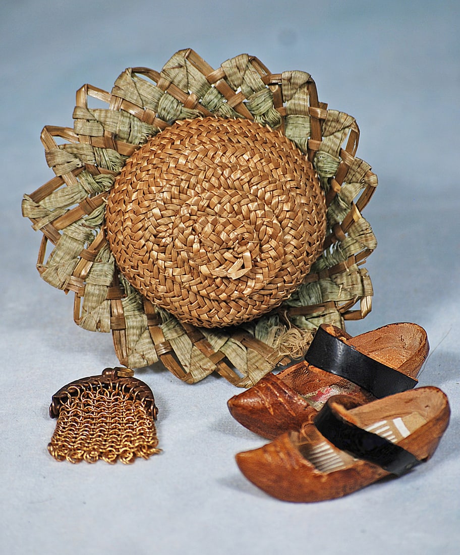 DOLL SHOES, BONNET AND PURSE: Intricately woven and firmly shaped woven straw bonnet with pinked-out woven straw brim, sized for approximately 5 ½” head circumference; pair of 2” carved wooden sabot shoes; and tin