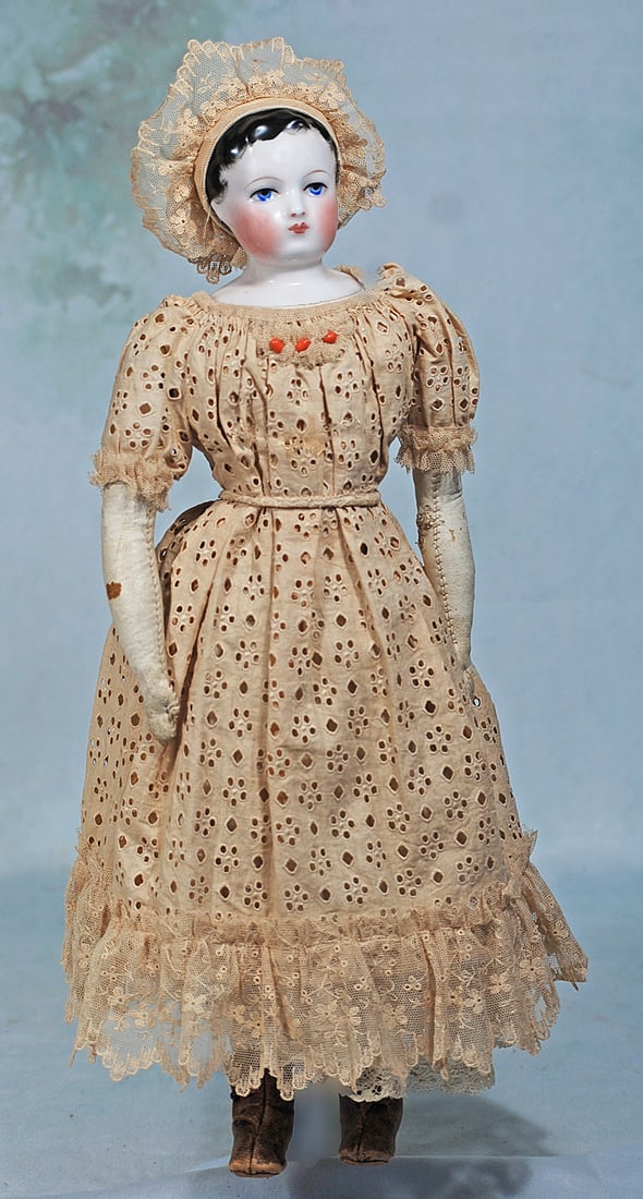 EARLY FRENCH PORCELAIN FASHION LADY ATTRIBUTED TO GAULTHIER, WITH ORIGINAL BODY: 16 ½”. Porcelain shoulderhead with lightly tinted pink complexion, painted black hair with brushstroke detail all around the face, modeled ears, painted large blue eyes, thick upper eyeline