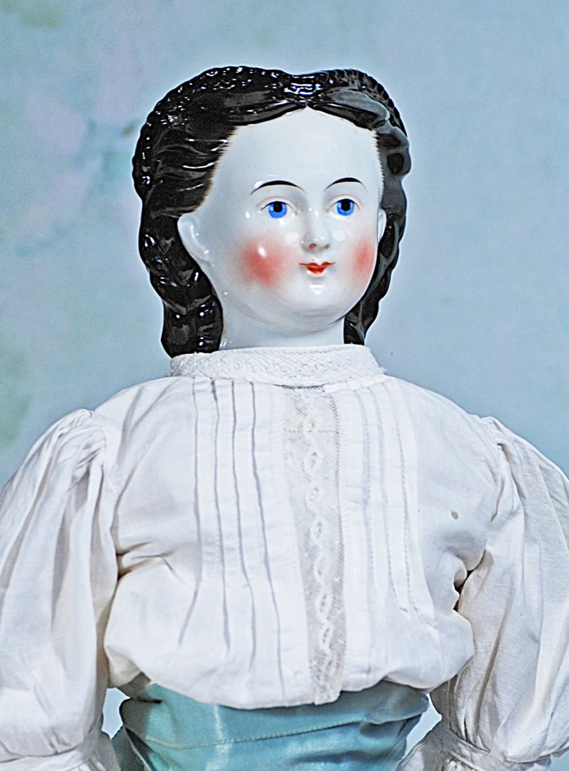 LARGE GERMAN PORCELAIN LADY WITH RARE COIFFURE: 23”. Porcelain shoulderhead, sculpted black hair drawn away from her face, accented with a heart-shaped ridge of tiny tight curls, hair at her back captured by a detailed snood which falls down 