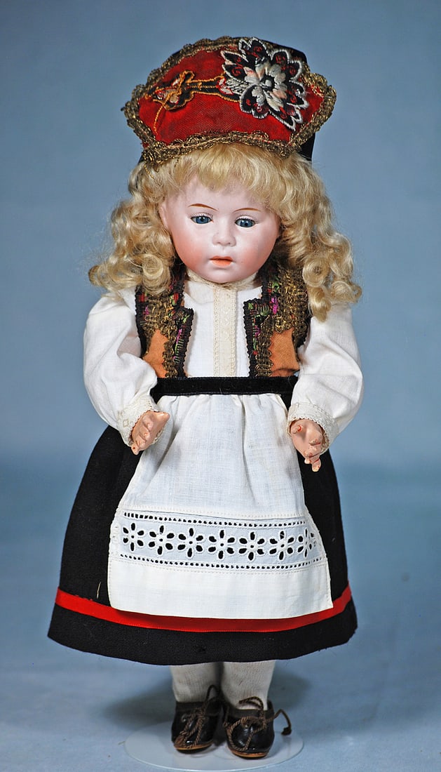 PETITE GERMAN BISQUE "DIP” POUTY CHARACTER CHILD BY SWAINE: 10 ½”. Marks: DIP. Bisque socket head, blue sleep eyes, painted lashes, feathered brows, closed mouth, plump cheeks, closed mouth, blonde mohair wig, composition and wooden jointed toddler 