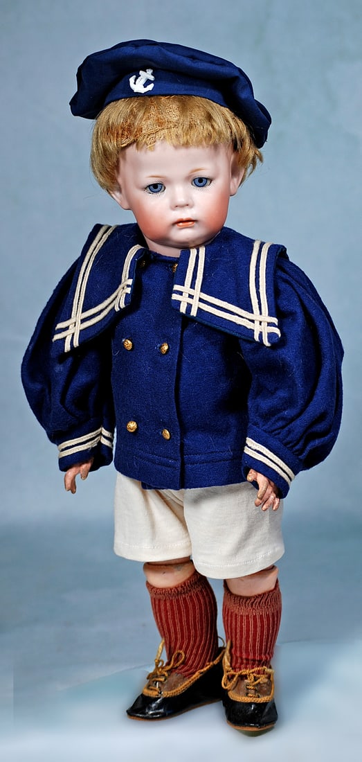 GERMAN BISQUE CHARACTER BOY, 115/A, KNOWN AS PHILLIP, BY KAMMER AND REINHARDT: 13”. Marks: K * R Simon & Halbig 115/A. Bisque socket head, rounded plump face, pouty expression, blue sleep eyes, painted lashes, eyeliner, feathered brows, closed mouth, accented lips, blonde 