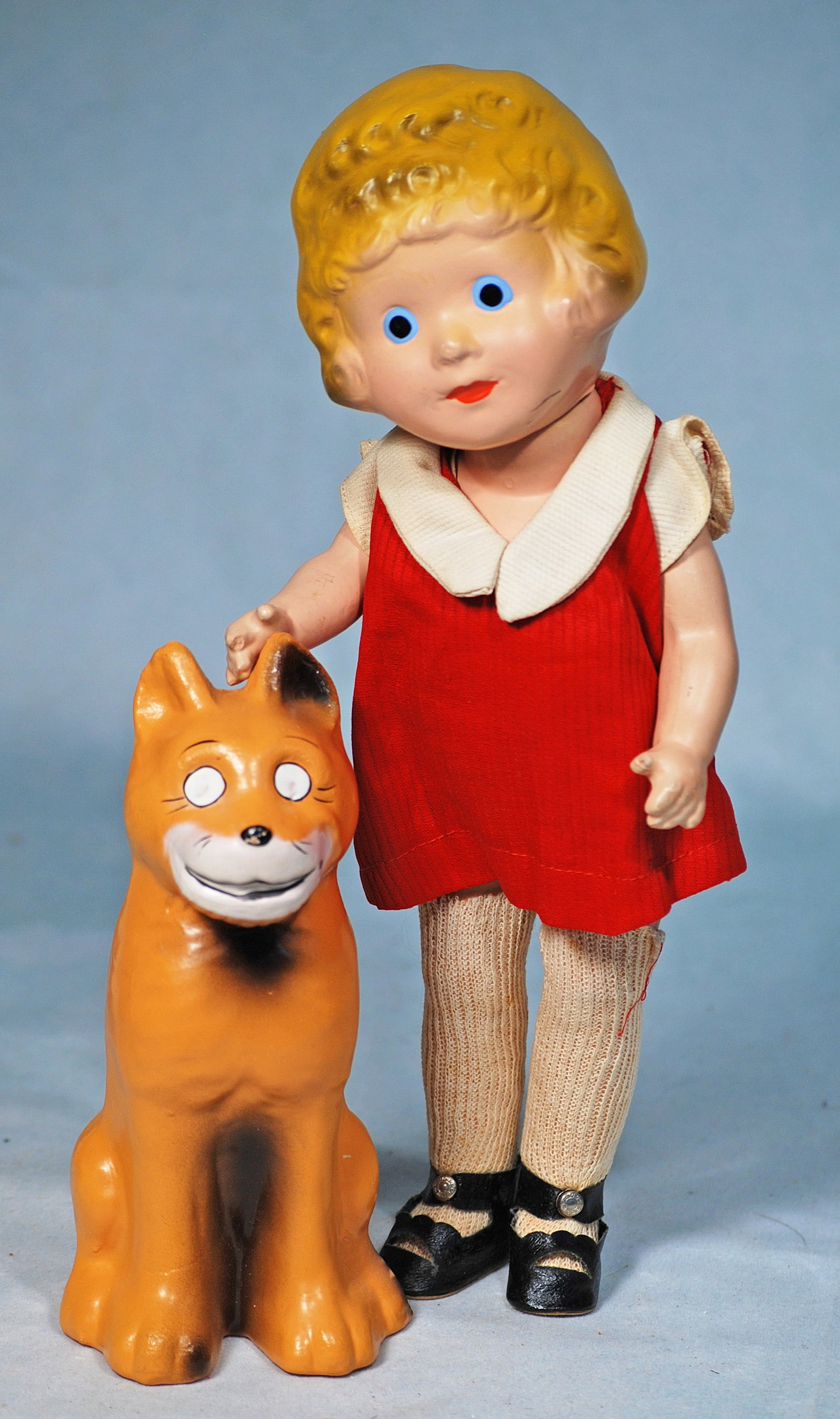 AMERICAN COMPOSITION LITTLE ORPHAN ANNIE AND SANDY: 12”. All composition doll with socket head, sculpted blonde curly hair, painted blue eyes, closed mouth, jointed arms and legs, red cotton dress, black leather shoes; along with beloved dog, San