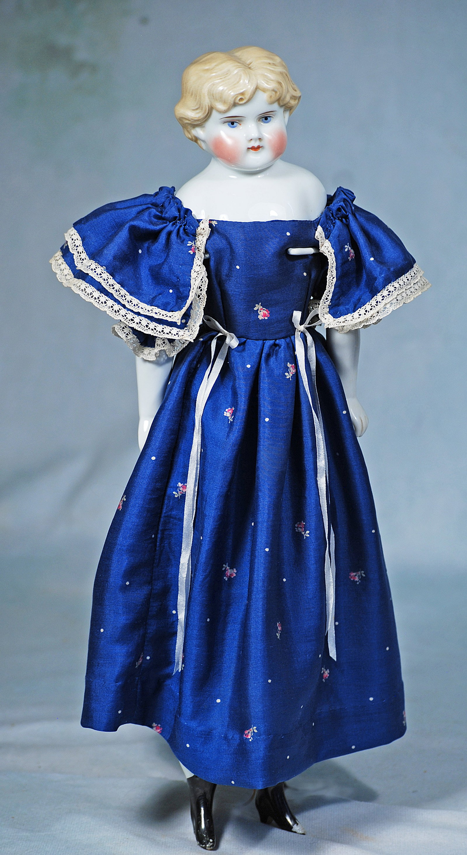 GERMAN PORCELAIN LADY BY ALT, BECK AND GOTTSCHLACK: 14”. Marks: 1046 #4. Porcelain shoulderhead, sculpted blonde hair, center-parted with forehead curls and short curls waved behind partially modeled ears, painted blue eyes, red and black