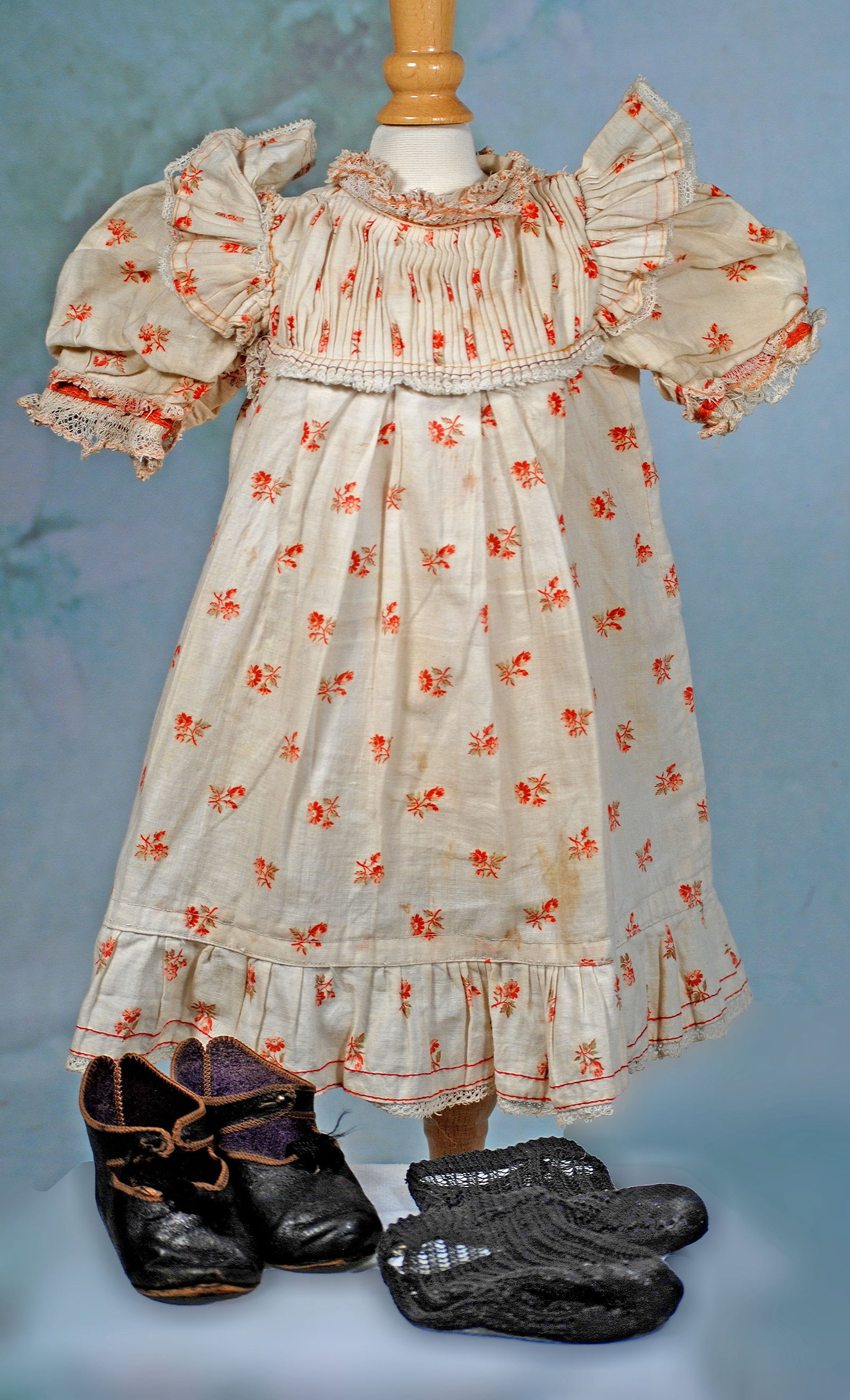 JUMEAU CHEMISE AND PAIR OF JUMEAU DOLL SHOES: 299. JUMEAU CHEMISE AND PAIR OF JUMEAU DOLL SHOES. Cotton print Jumeau chemise dress with pleated yoke and bretelles, gathered skirt with ruffle, lace trimming; 5” shoulder width, 13”