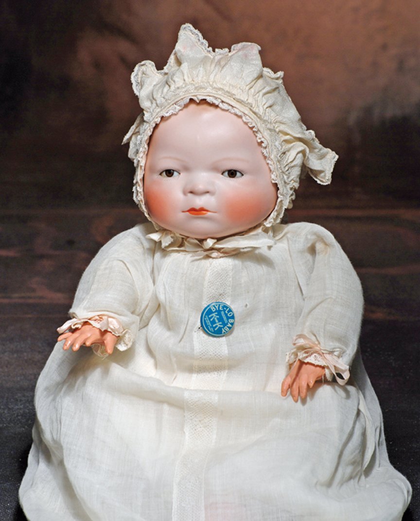 ALL-ORIGINAL GERMAN BISQUE BYE-LO BABY WITH BROWN EYES.: ALL-ORIGINAL GERMAN BISQUE BYE-LO BABY WITH BROWN EYES. Marks. Copr. by Grace S. Putnam. 14” L. Solid-dome bisque head with flange neck, molded and painted curly brown hair, brown sleep eyes, painte