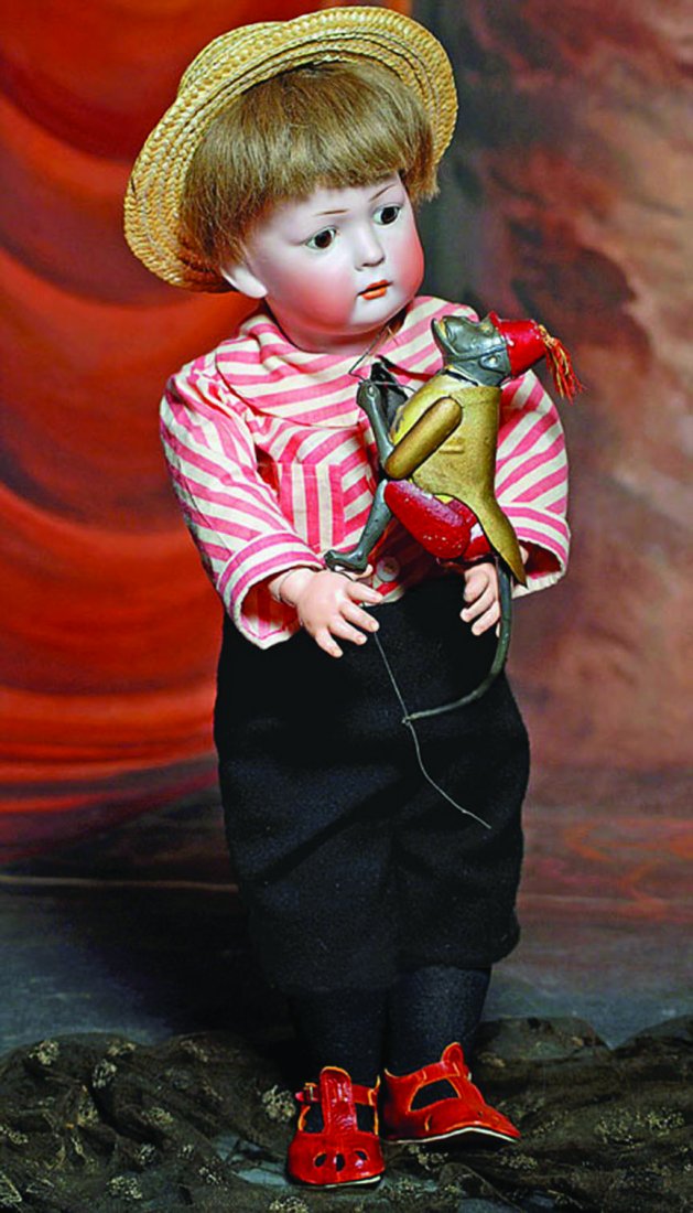 GERMAN TIN TOY “CLIMBING MONKEY” BY LEHMANN. 7". Tin: GERMAN TIN TOY “CLIMBING MONKEY” BY LEHMANN. 7". Tin figure of circus monkey has painted gold jacket with red pants and cap; hinged arms and legs, designed with pull strings to allow the monkey to