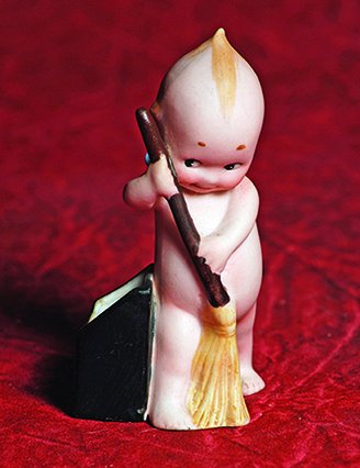 GERMAN BISQUE KEWPIE SWEEPER. Marks: O’Neill/ C. in: GERMAN BISQUE KEWPIE SWEEPER. Marks: O’Neill/ C. in circle stamp. 3 ¾”. All-bisque Kewpie posed with broom stands alongside an open black dust bin. Commentary: Excellent condition.