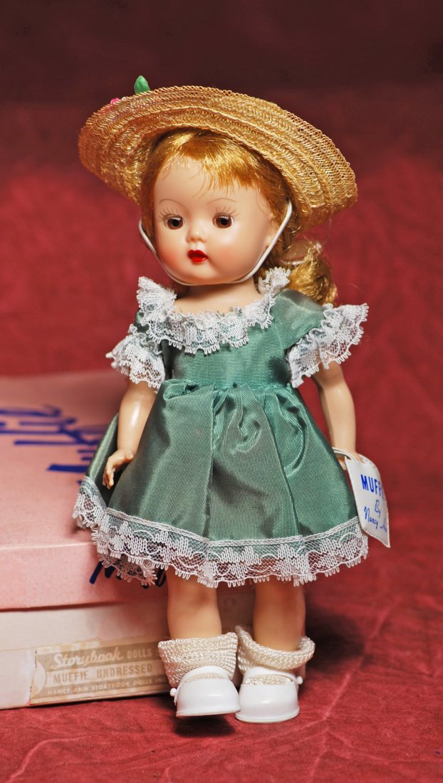 “MUFFIE BY NANCY ANN STORYBOOK DOLLS. 8”. Hard: “MUFFIE BY NANCY ANN STORYBOOK DOLLS. 8”. Hard Plastic walker, brown sleep eyes, molded and painted eyelashes, blonde wig in ponytail, tagged green taffeta dress with lace trim, taffeta panty, str
