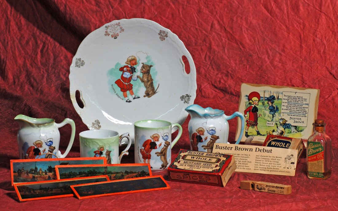 GERMAN PORCELAIN “BUSTER BROWN” DISHES AND MEMORABILIA.: GERMAN PORCELAIN “BUSTER BROWN” DISHES AND MEMORABILIA. Includes: 9” diameter plate, two 4” tall pitchers, and two mugs; Four glass slides for viewing with a magic lantern, glass bottle of Bus