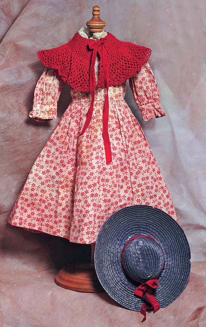 ANTIQUE COTTON PRINT DOLL DRESS, CROCHETED CAPE, AND: ANTIQUE COTTON PRINT DOLL DRESS, CROCHETED CAPE, AND STRAW BONNET. Dress of red cotton print with fitted bodice, gathered sleeves with ruffles, gathered skirt, back button closing, lace neck trim, 4 �
