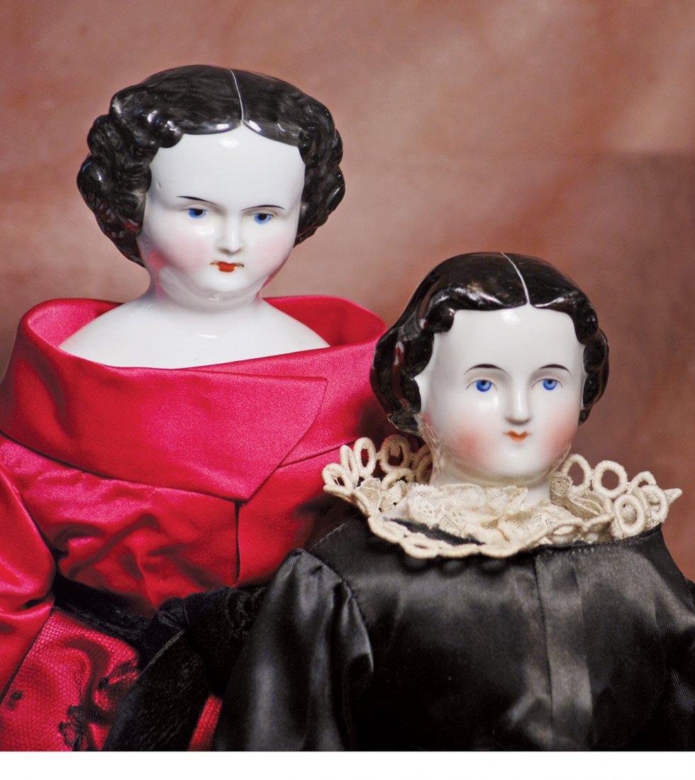 TWO GERMAN CHINA DOLLS. 16 ½” and 18” dolls. Each has: TWO GERMAN CHINA DOLLS. 16 ½” and 18” dolls. Each has porcelain shoulderhead with painted black hair in center-part style, painted blue eyes, red and black lid lines, tapered brows, closed mouth,
