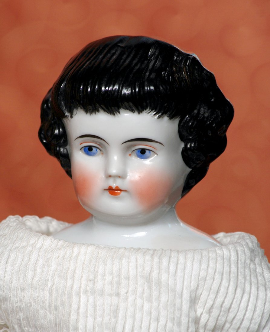 GERMAN CHINA DOLL WITH BANGS BY ALT, BECK & GOTTSCHALCK: GERMAN CHINA DOLL WITH BANGS BY ALT, BECK & GOTTSCHALCK. Marks: 1000#3. 13”. Porcelain shoulderhead, sculpted and painted short black curly hair with comb-marked bangs and stippled detail, painted f