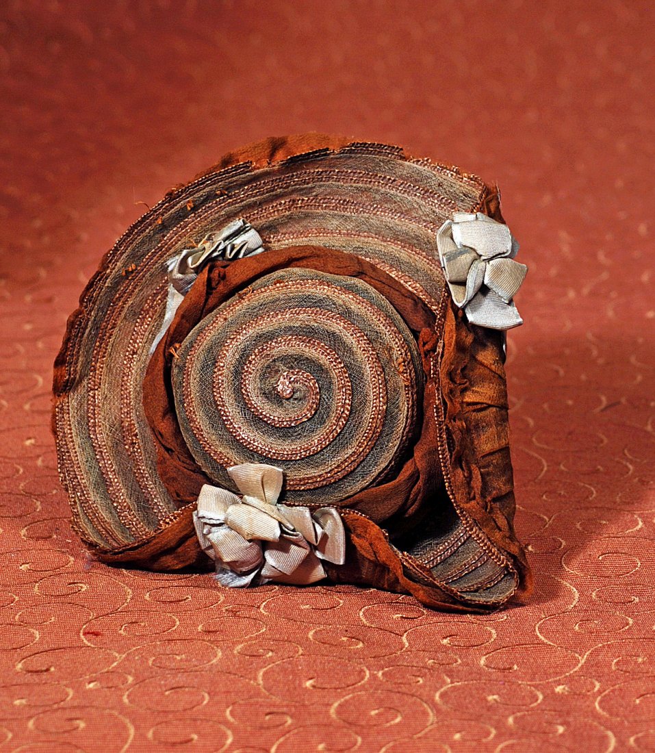 ANTIQUE STRAW BONNET WITH BLUE RIBBONS: ANTIQUE STRAW BONNET WITH BLUE RIBBONS. 3 ¼” inside cap width. Straw bonnet woven in circular pattern with 2” deep upturned brim, brown silk organza shirred brim and twisted crown band, accented
