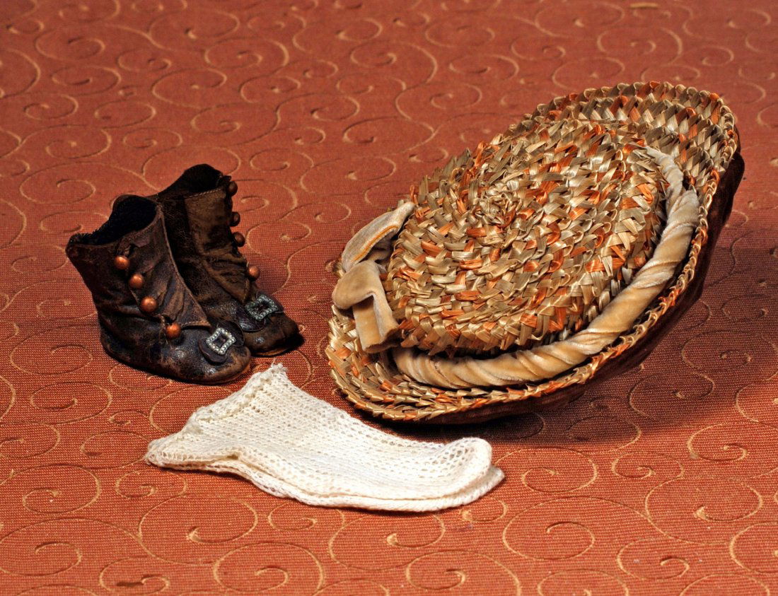 ANTIQUE DOLL BONNET, BOOTS AND SOCKS: ANTIQUE DOLL BONNET, BOOTS AND SOCKS. Brown leather boots with four-button side closings, leather bows, embossed silver buckles, leather soles, 2 ¼” length; Pair white woven cotton socks, height 4�