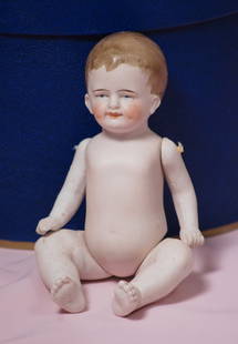 GERMAN ALL-BISQUE CHARACTER BABY. Marks: None. 7”.: GERMAN ALL-BISQUE CHARACTER BABY. Marks: None. 7”. All-bisque baby with sculpted and painted brown hair which is brushed forward, jointed at shoulders and hips, painted features, blue eyes with