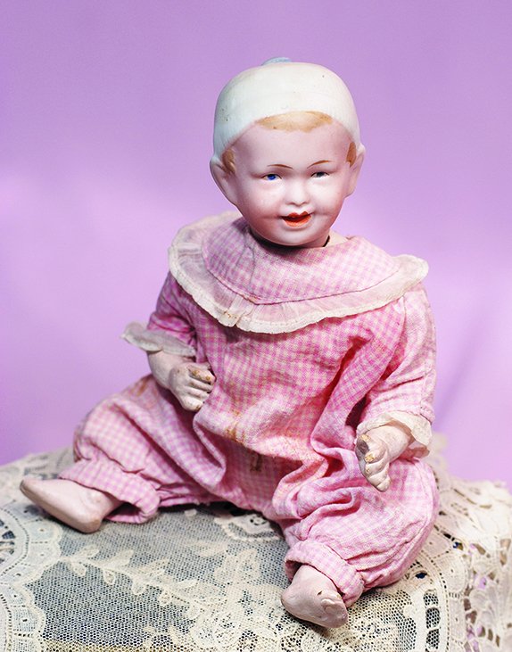 GERMAN BISQUE CHARACTER BOY WITH MOLDED CAP BY: GERMAN BISQUE CHARACTER BOY WITH MOLDED CAP BY RECKNAGEL. Marks: R A 28-19. 8 1/2". Bisque socket head, molded and painted white cap and brown hair, painted features, intaglio blue eyes, upper eyeline