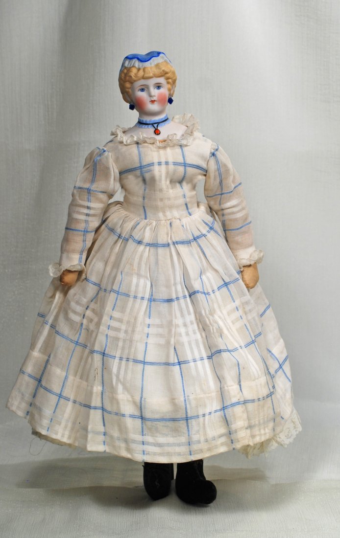 RARE GERMAN BISQUE LADY WITH SCULPTED CAP AND NECKLACE.: RARE GERMAN BISQUE LADY WITH SCULPTED CAP AND NECKLACE. 19”. Bisque shoulderhead with sculpted blonde curls waved behind the ears and topped with blue and white ruffled cap, painted blue eyes, red a
