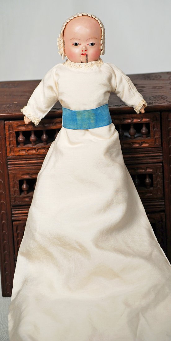 GERMAN WAX-OVER-PAPIER MACHE TAUFLING BABY. Solid: GERMAN WAX-OVER-PAPIER MACHE TAUFLING BABY. Solid domed wax-over-papier mache baby with brown glass eyes, painted brows and lips, hinged jaw allowing the mouth to open to reveal painted teeth, slender