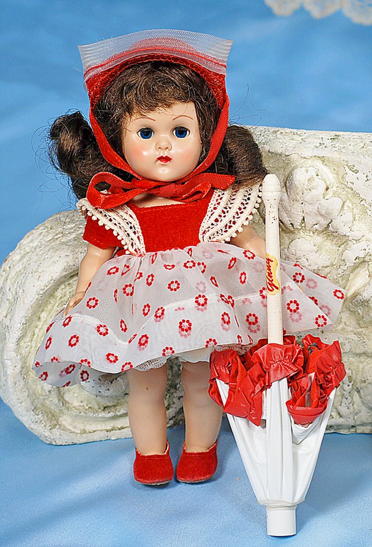 VOGUE GINNY “BON BONS SERIES” NO. 85. 8”. Hard plastic,: VOGUE GINNY “BON BONS SERIES” NO. 85. 8”. Hard plastic, straight-leg walker, blue sleep eyes, molded lashes, brunette wig, tagged red and white flocked nylon dress, taffeta panty, petticoat, red
