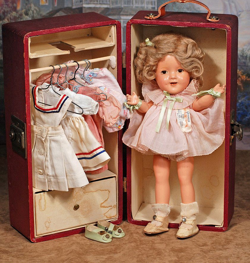 COMPOSITION, IDEAL SHIRLEY TEMPLE, WITH TRUNK AND: COMPOSITION, IDEAL SHIRLEY TEMPLE, WITH TRUNK AND WARDROBE.Marks:11 Shirley Temple.Composition socket head on five-piece jointed composition body, mohair wig, sleep eyes, painted and applied eyelashes