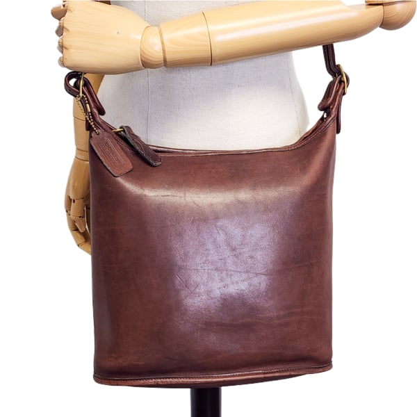 Vintage COACH Shoulder Sac 9730 in Brown w/ Brass Hardware & Hang Tag: Vintage Coach Shoulder Sac 9730 in Brown w/ Brass Hardware & Hang Tag. Adjustable crossbody strap. Zip top closure. Interior pocket. Some visible wear/surface scuffs and/or scratches, worn spots on pi