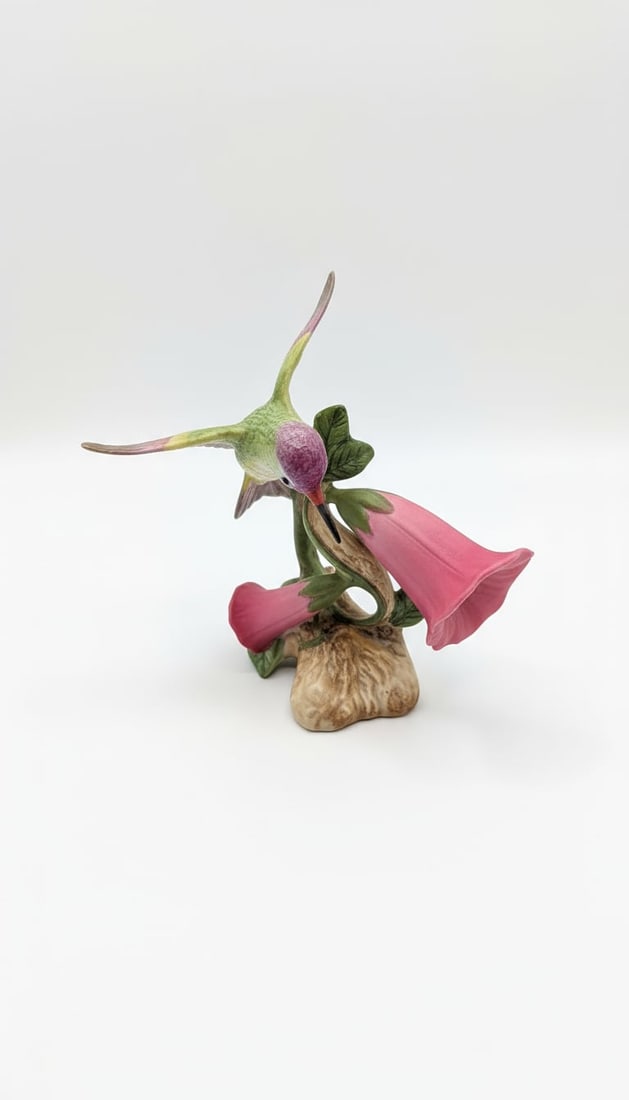 Bowen Porcelain Lucifer Hummingbird Figurine: This is a charming porcelain figurine depicting a hummingbird, identified as a 'Lucifer' hummingbird, interacting with foxglove flowers. The piece is crafted with intricate detail, capturing the delic
