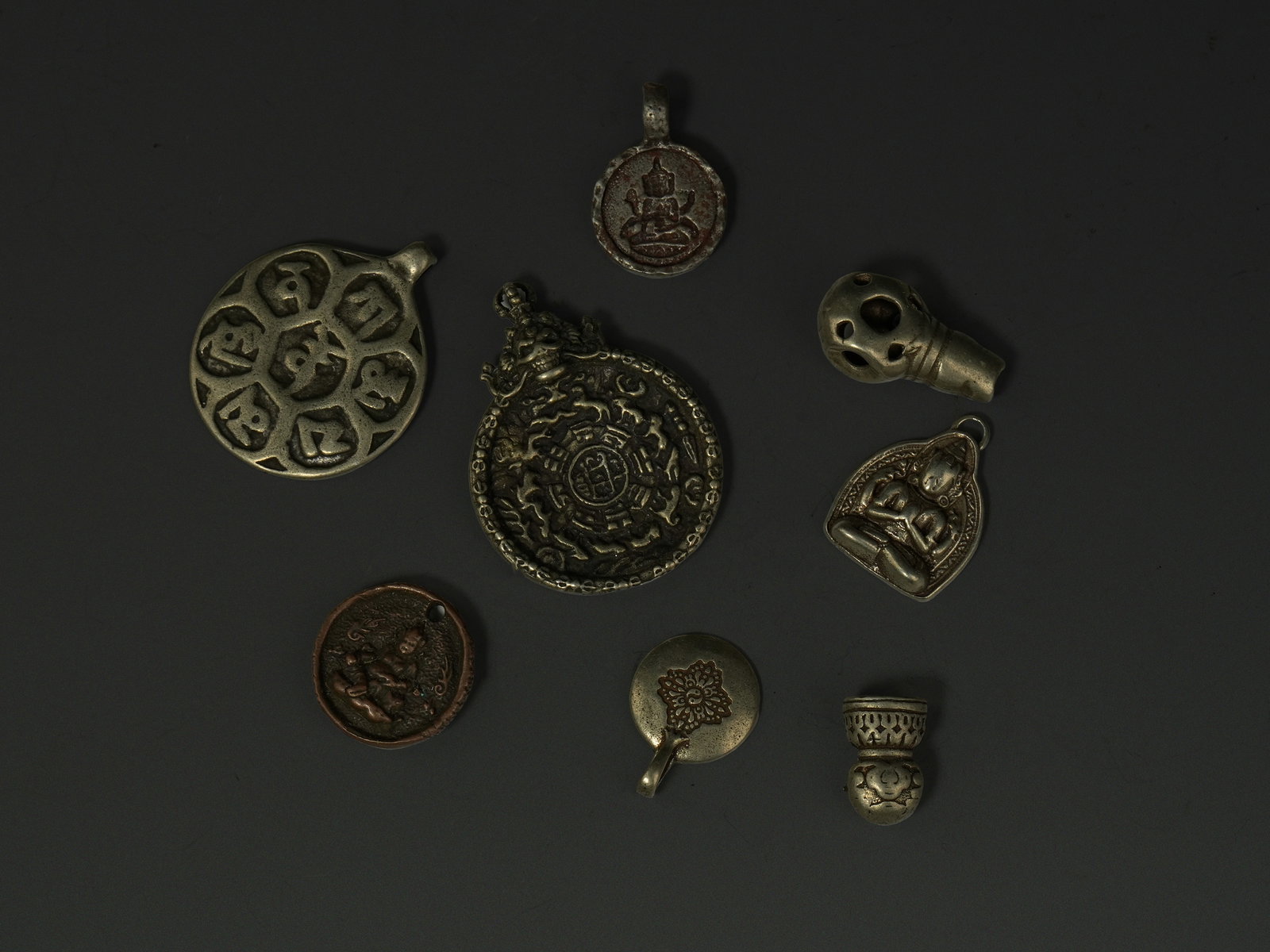 A Collection of Tibetan Ritual Amulets and Pendants in Mixed Metal. (1 of 2)