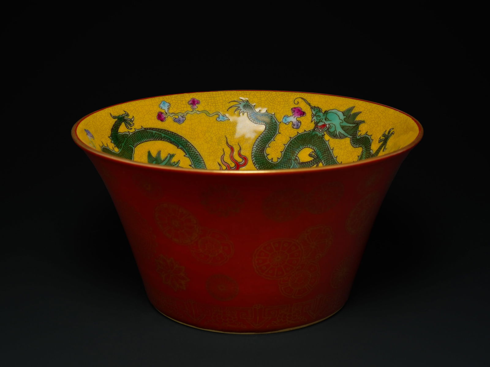 A Chinese Red-Ground Porcelain Bowl with Yellow Dragon Interior and Turquoise Base.: A Chinese porcelain bowl of deep, flaring form, the exterior finished in a rich iron-red ground delicately decorated with gilt medallions and scrolling motifs. The interior is vividly enamelled in yel