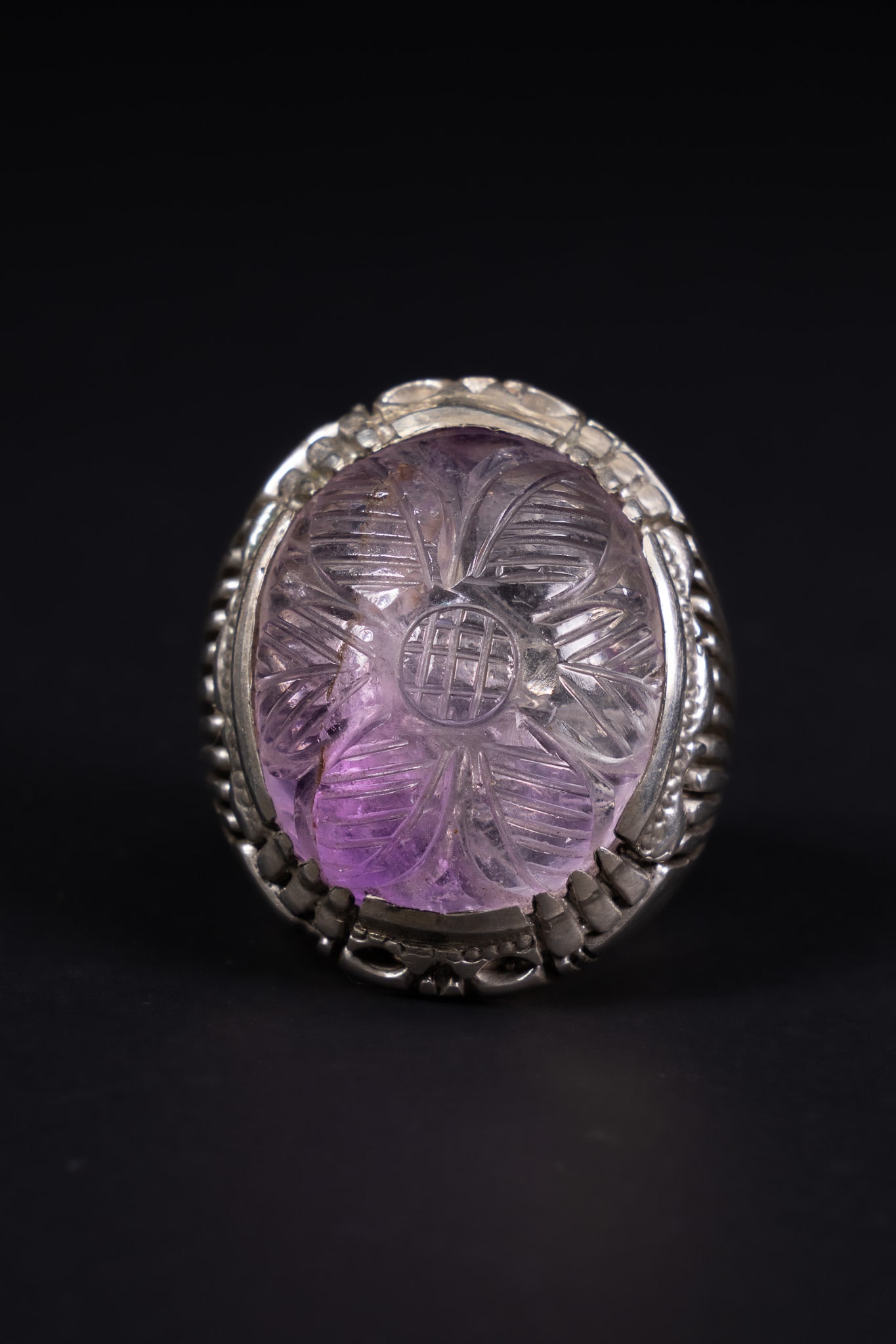 A SILVER AND CARVED AMETHYST STATEMENT RING. (1 of 2)