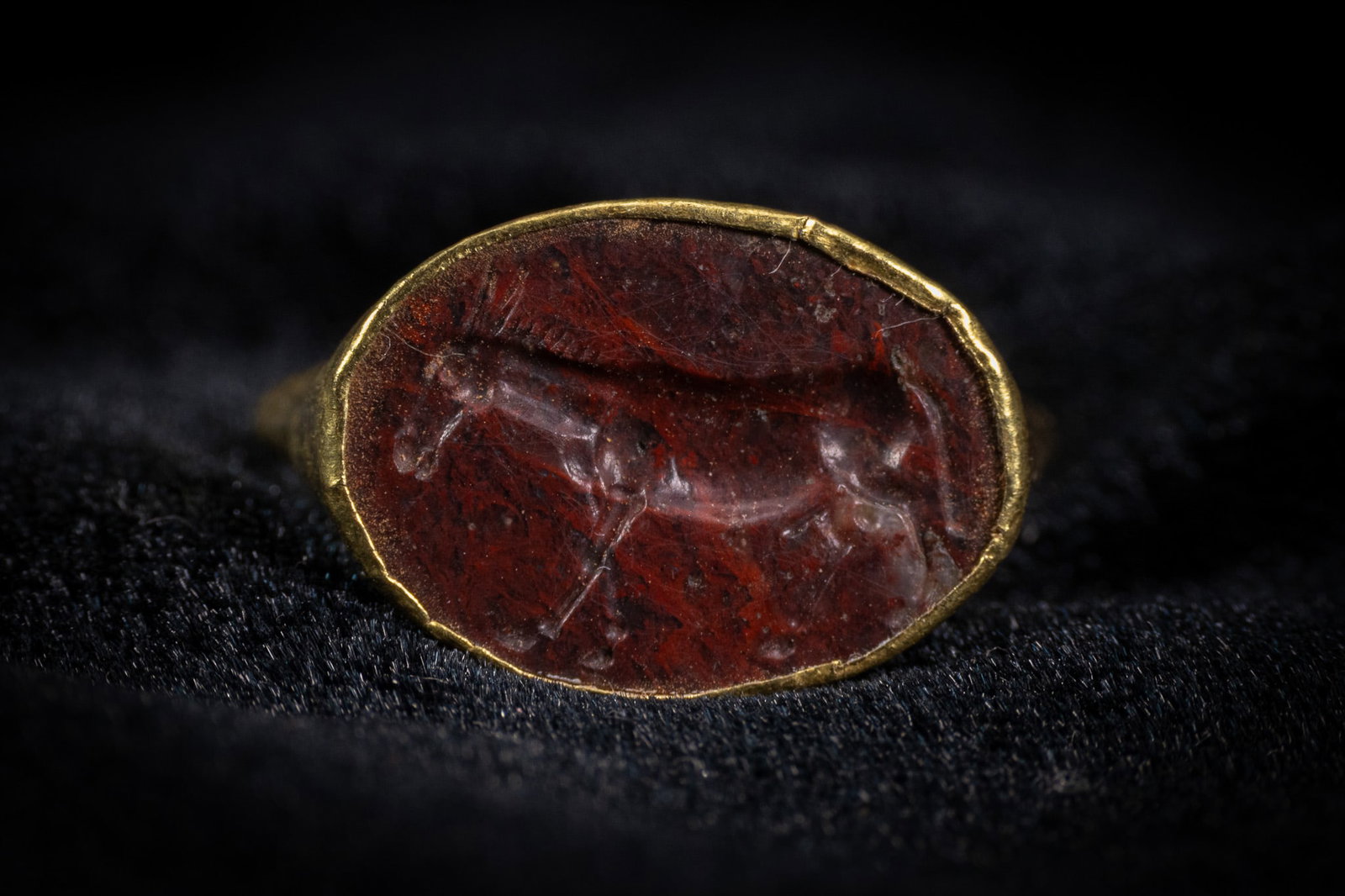 A ROMAN GOLD AND CARNELIAN INTAGLIO SIGNET RING, CIRCA 2ND CENTURY AD. (1 of 2)