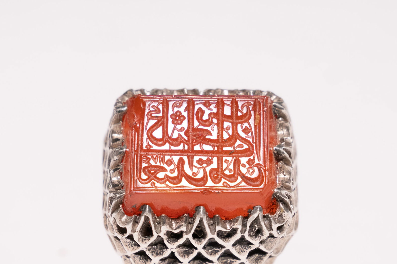 AN ISLAMIC SILVER AND ENGRAVED CARNELIAN SIGNET RING WITH QURANIC INSCRIPTION. (1 of 2)