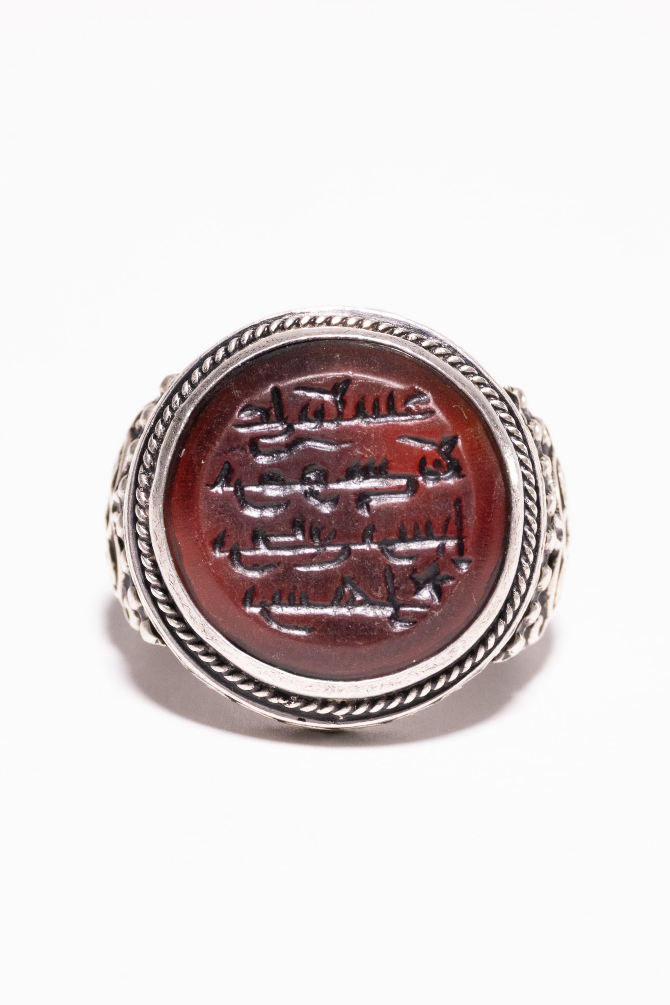 AN ISLAMIC SILVER AND RED AQEEQ INTAGLIO SEAL RING. (1 of 2)