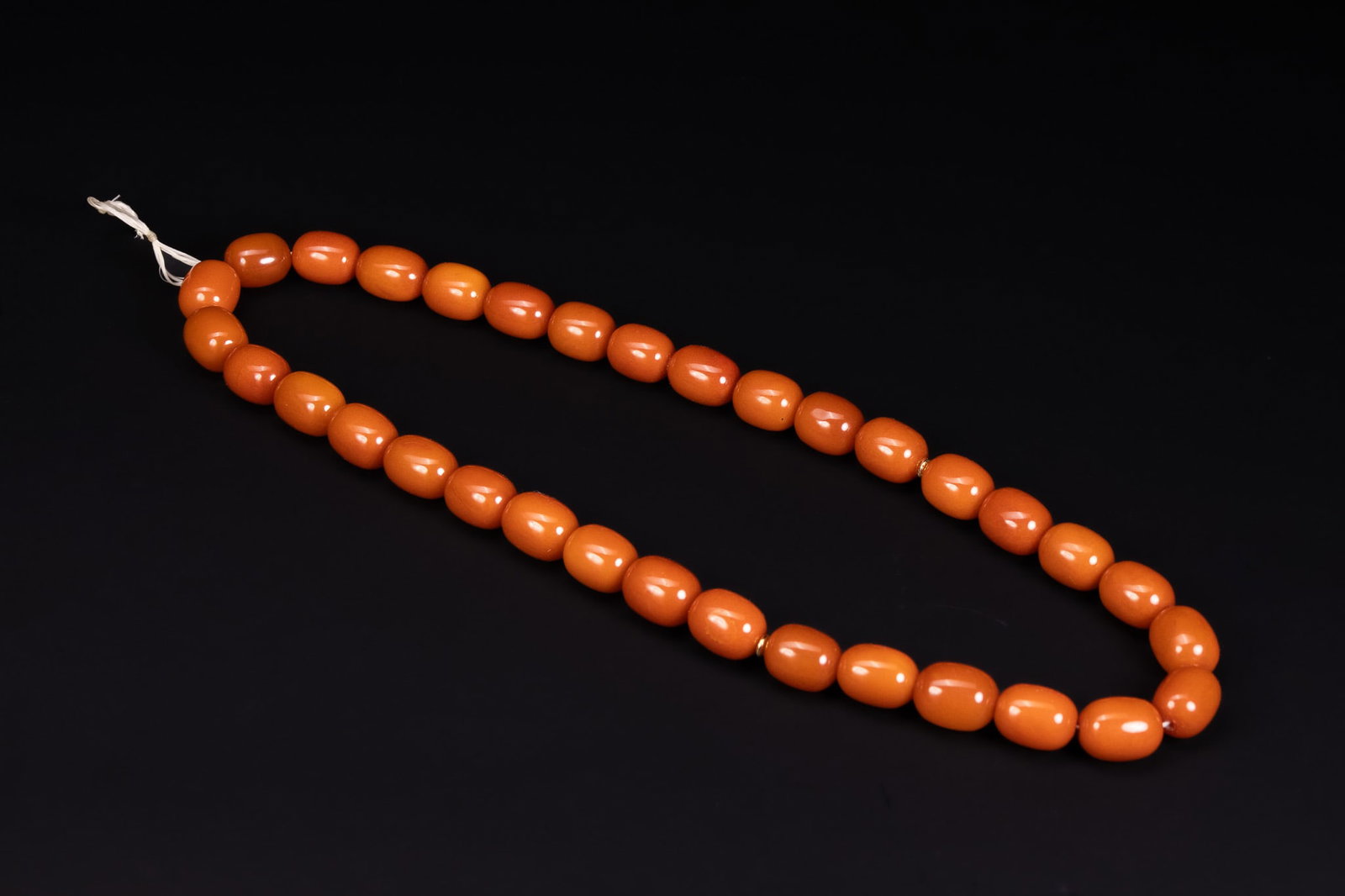 AN ISLAMIC BUTTERSCOTCH AMBER 33 BEAD NECKLACE. (1 of 4)