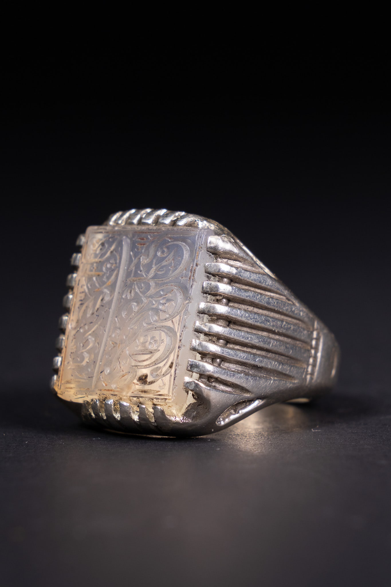 AN ISLAMIC SILVER AGATE SIGNET RING WITH CALLIGRAPHIC INTAGLIO. (1 of 2)