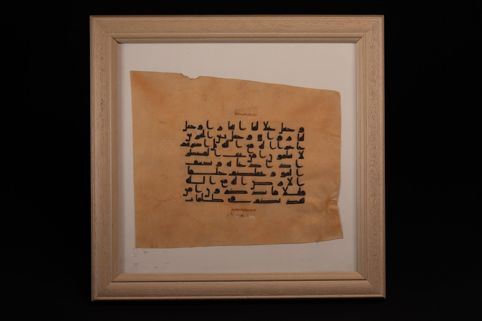 AN ISLAMIC QUR'AN LEAF FRAGMENT IN KUFIC SCRIPT ON VELLUM. (1 of 4)