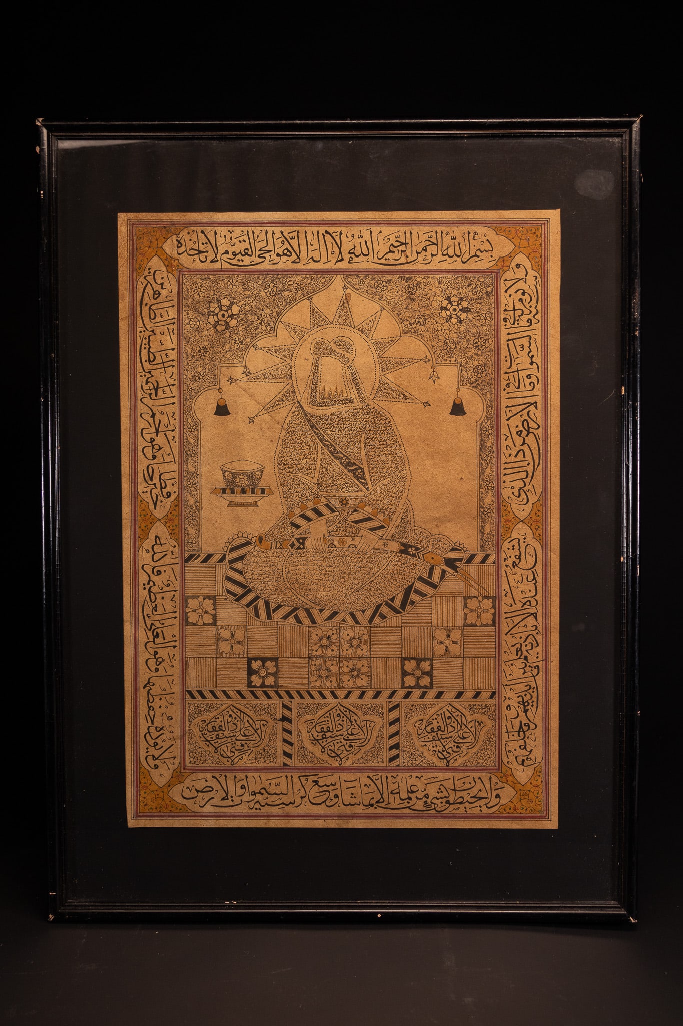 QAJAR SCHOOL, LATE 19TH OR EARLY 20TH CENTURY, 'A CALLIGRAPHIC COMPOSITION DEPICTING THE IMAM ALI: A calligraphic composition, known as a shamail, executed in ink and polychrome pigments on paper. The central seated figure represents the Imam Ali, depicted with a veiled face and a large radiant hal