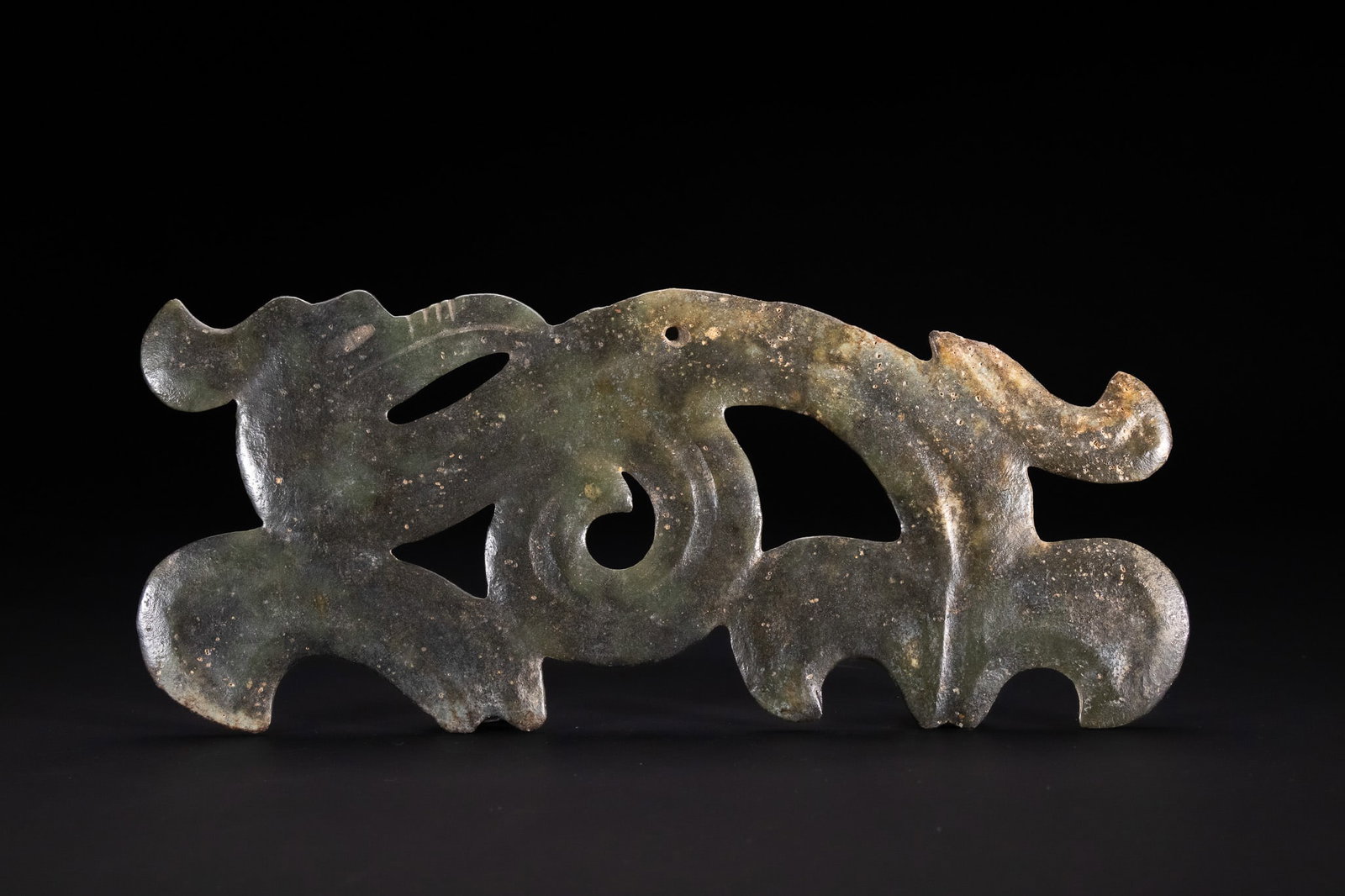 A CHINESE ARCHAIC STYLE CARVED GREEN JADE OPENWORK DRAGON-FORM PENDANT. (1 of 2)
