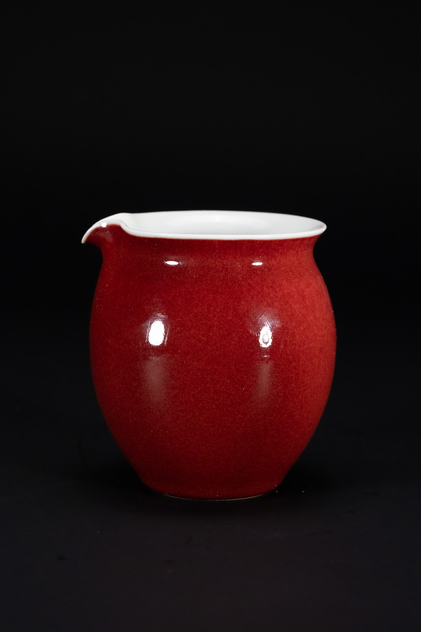 A CHINESE MONOCHROME COPPER-RED GLAZED PORCELAIN POURING VESSEL, YONGZHENG MARK. (1 of 3)