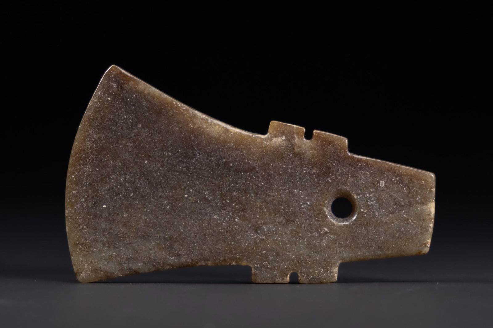 A CHINESE ARCHAIC STYLE MOTTLED JADE RITUAL AXE HEAD, YUE. (1 of 2)