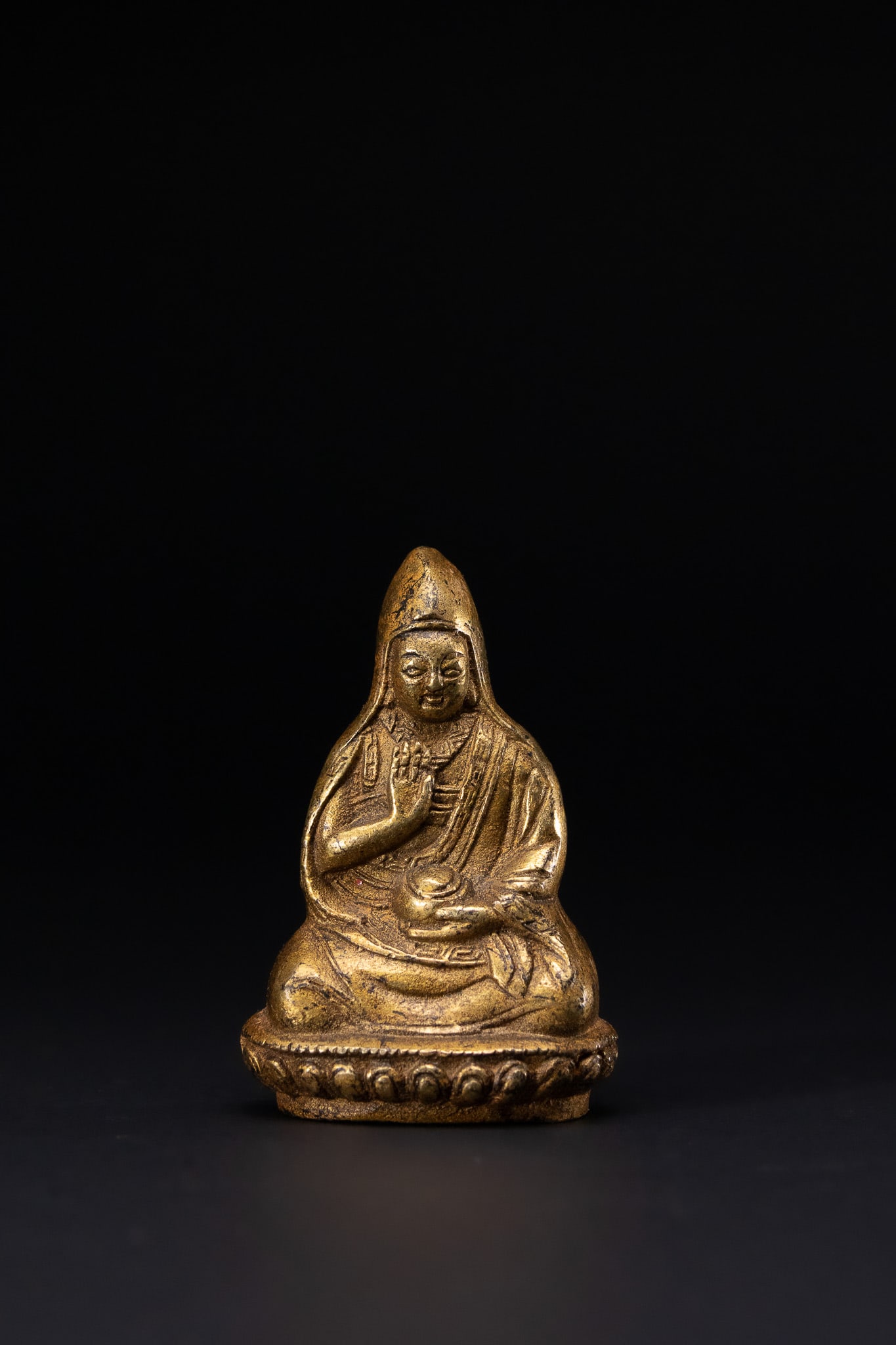 A SINO-TIBETAN GILT-BRONZE FIGURE OF A LAMA, QING DYNASTY OR LATER. (1 of 3)