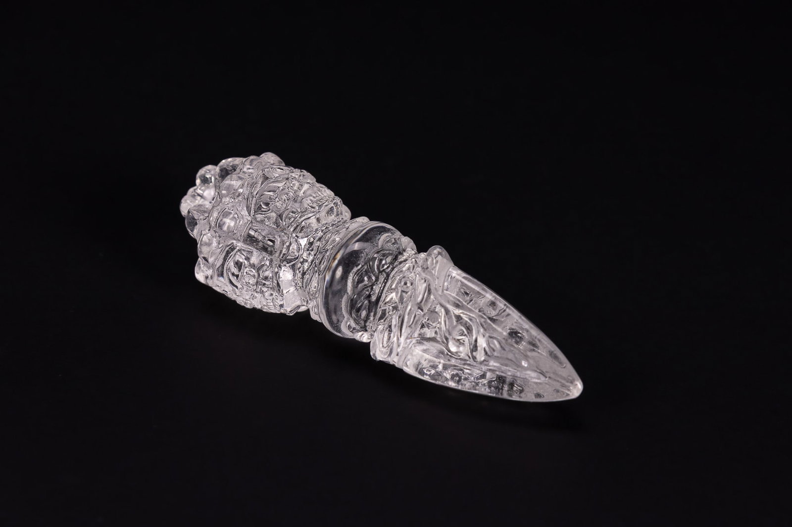 A TIBETAN CARVED ROCK CRYSTAL OR GLASS PHURBA. (1 of 2)