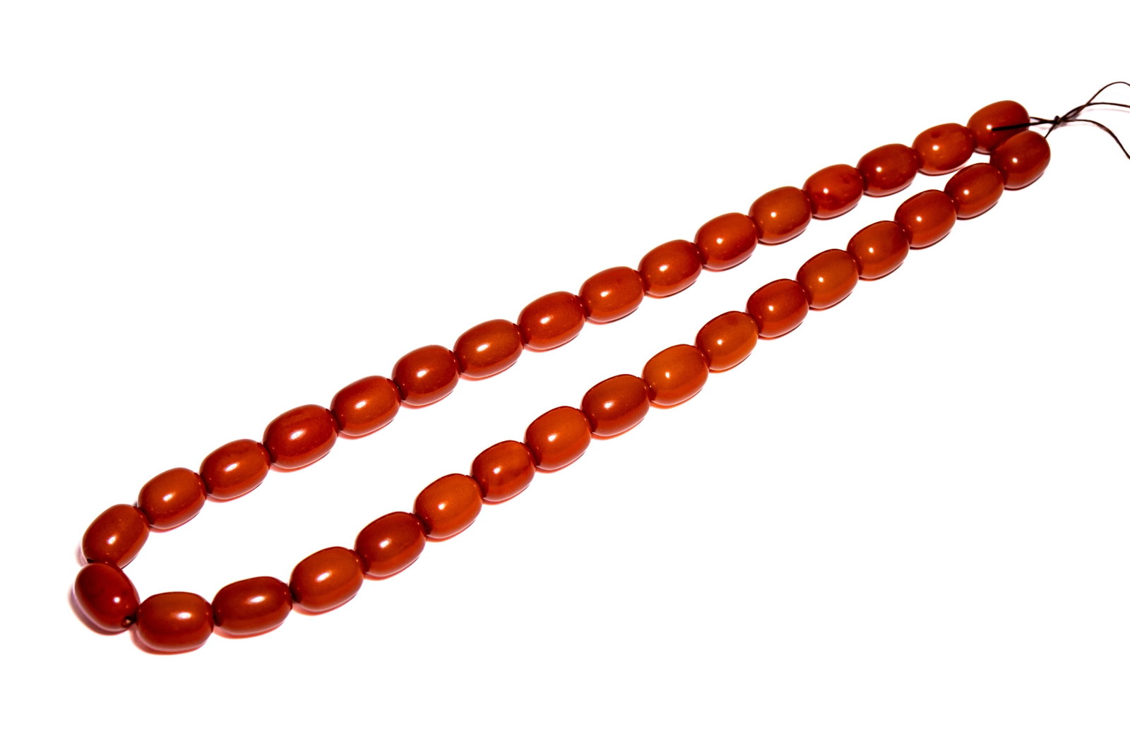 A STRAND OF THIRTY-THREE AMBER MISHABA BEADS. (1 of 3)